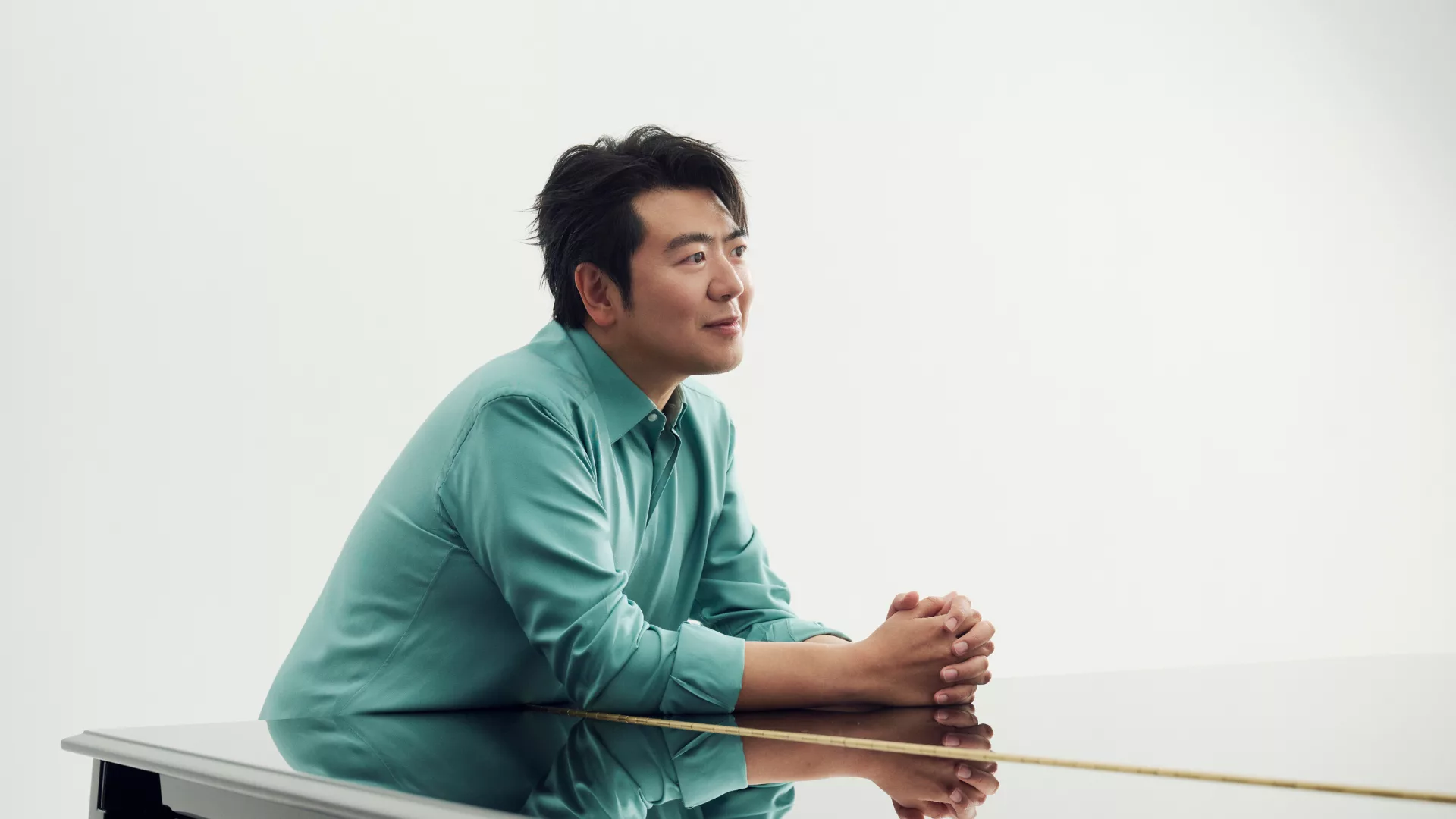 Il pianista Lang Lang appoggiato al pianoforte