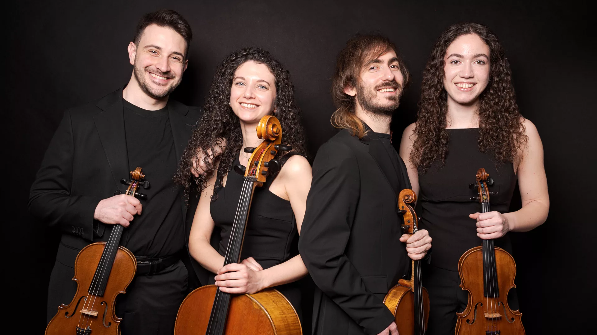 Foto dei componendi del quartetto d'archi Doré Quartet mentre tengono in mano gli strumenti